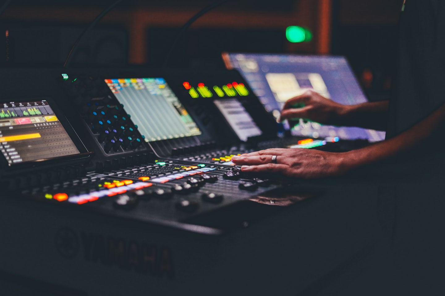 Un tecnico audio regola i fader su una console di missaggio audio.